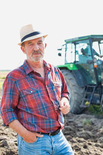 istock Senior farmer standing in field 1192426698