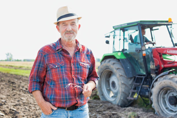 istock Senior farmer standing in field 1192426744