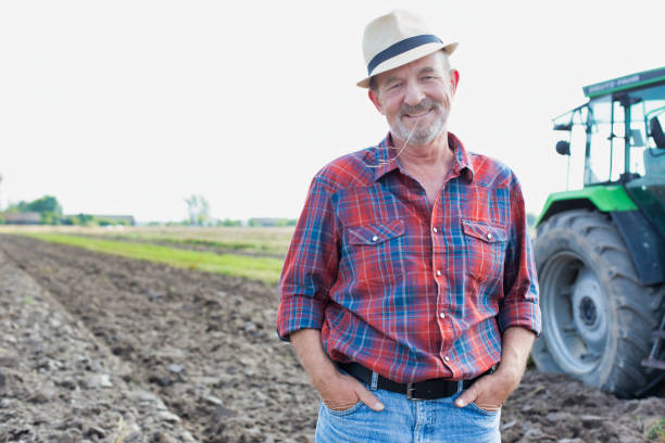 istock Senior farmer standing in field 1192426754