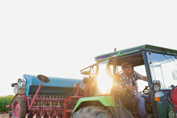 istock Farmer driving tractor in field 1192429667