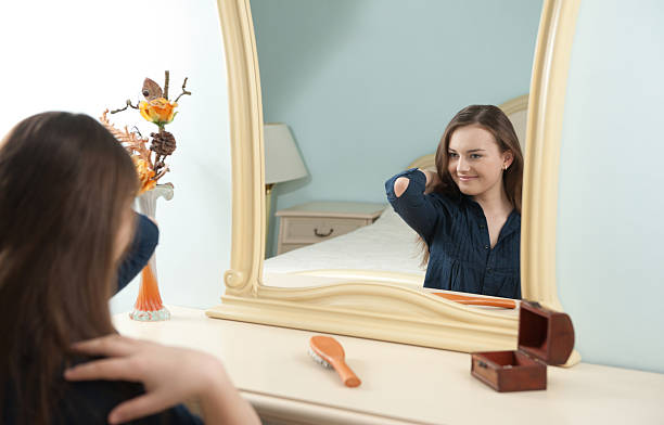 Jovem Garota em frente a um espelho - foto de acervo