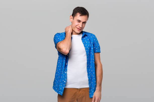 istock Unsure man stroking neck expressing doubtful emotion isolated over grey background 1192431009