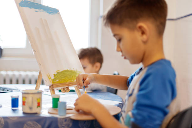 istock Boy at home painting on canvas at home 1192441230