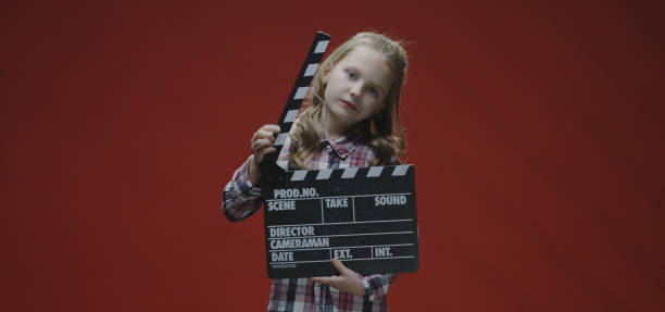 istock Girl clapping clapboard and raising eyebrows 1192443667