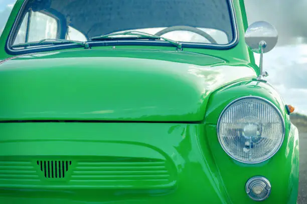 green little retro car. retro car concept. view of the front of the car and the headlight