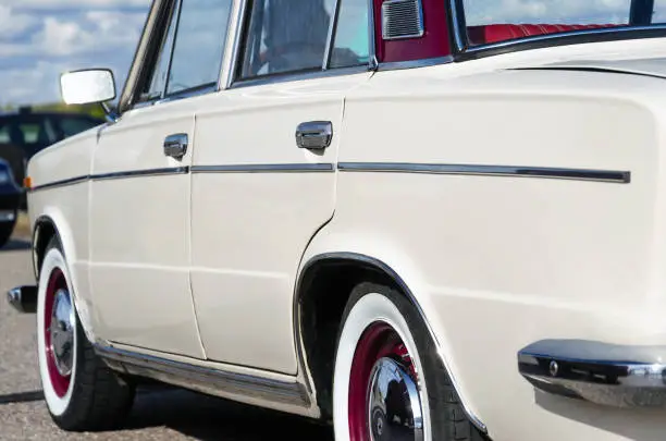 vintage car. beige retro car. on the chrome details a sunny highlight. rear side view. sun against the sky. retro car travel concept