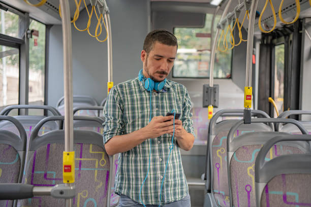 istock Handsome Man is Standing in Public Bus and Using his Smartphone 1192445350