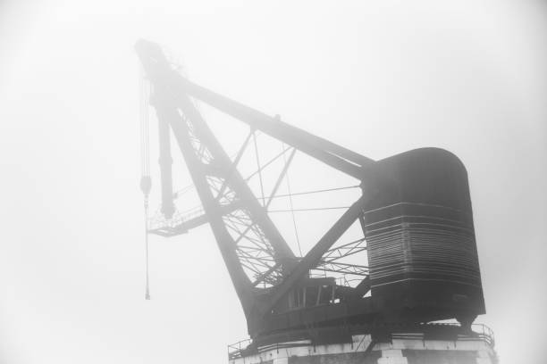 A ancient crane in the historic Arsenal of Venice, northern Italy. The fog lets the base be very visible, the top of the crane fades into the white of the humid air, giving the photo a eerie or dreamy appearance.