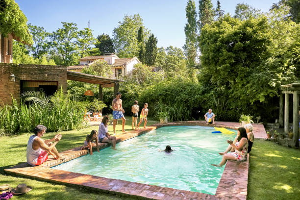 hispanic parents and children having fun at family pool - swimming pool water people sitting imagens e fotografias de stock