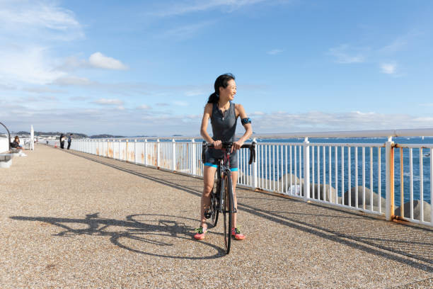 femme sur le vélo de route - mental health women asian ethnicity bicycle photos et images de collection