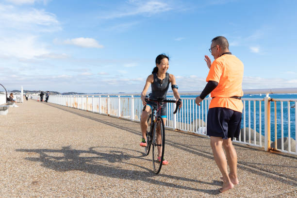 kobieta na rowerze szosowym spotkać przyjaciela biegacza - mental health women asian ethnicity bicycle zdjęcia i obrazy z banku zdjęć