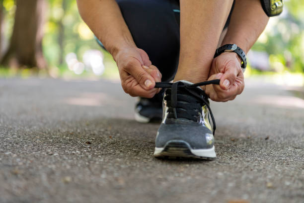 istock Senior Female Athlete Tying Sneaker Shoe 1192452310
