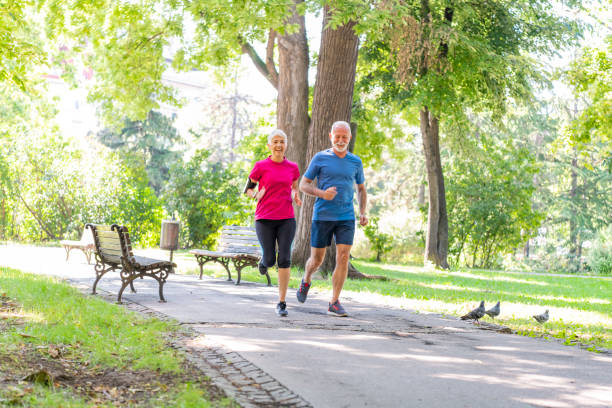 istock Active Senior Couple is Jogging Outdoors in Nature 1192453005