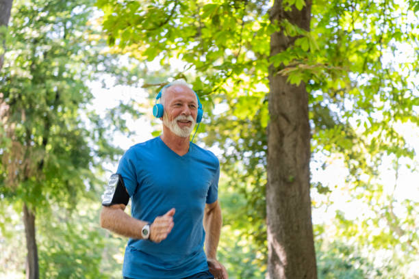 istock Handsome Mature Man is Jogging Outdoors in Nature 1192453088