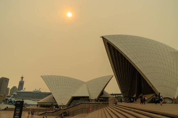 オペラハウスの上空と太陽は、ブッシュファイア、オーストラリア7-12-2019から重い赤い煙で覆われていました - global warming city smog heat ストックフォトと画像