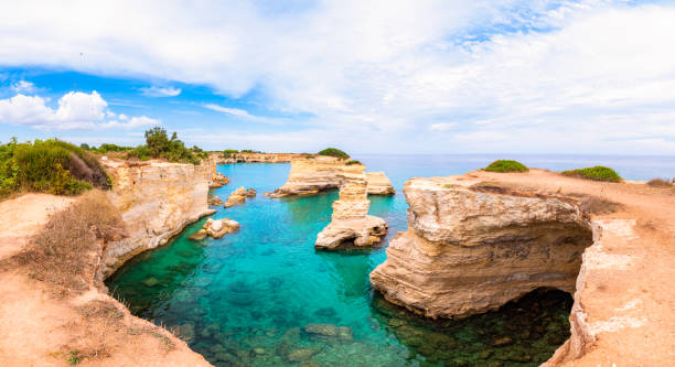 istock Torre Sant Andrea beach with its soft calcareous rocks and cliffs, sea stacks, small coves and the jagged coast landscape. Crystal clear water shape white stone create natural stacks. Melendugno Italy 1192461832