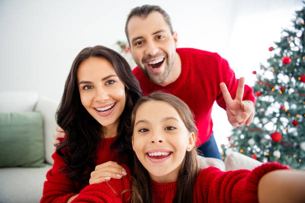 istock Self-portrait of three nice attractive lovely cute positive optimistic cheerful cheery glad excited family celebrating enjoying leisure showing v-sign in decorated light white interior living-room 1192464310