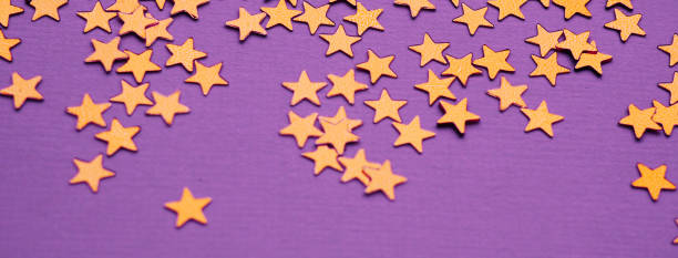 istock Golden stars glitter on lavender paper background 1192464962