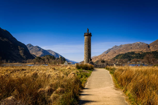 view over the Glenfinnan Monument at Loch Shiel with the mountains in the background; view over the Glenfinnan Monument at Loch Shiel with the mountains in the background; Glenfinnan, United Kingdom glenfinnan monument stock pictures, royalty-free photos & images