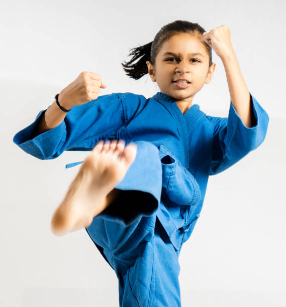 une fille asiatique/indienne affichant le combat de taekwondo sur le fond blanc - child sport karate education photos et images de collection