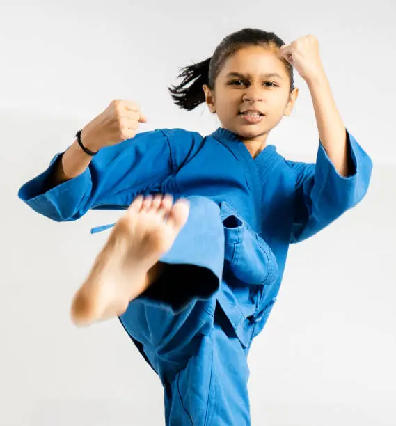Photo of An Asian/Indian girl posting Taekwondo fighting on white background