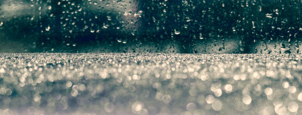 Rainy drops on the glass with the dark blue blurry background. Social media banner or header.