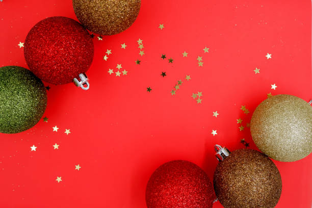 istock Christmas balls baubles on a red background with golden stars. Empty space for text input 1192474981