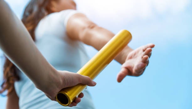 Two hands passing the baton for a relay race Two hands passing the baton for a relay race. relay photos stock pictures, royalty-free photos & images