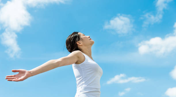 istock Young woman with hands stretched against sky 1192475266