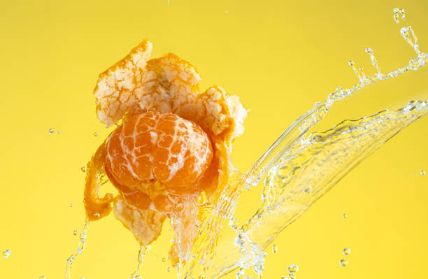 tangerine is almost peeled with a spray of water hanging