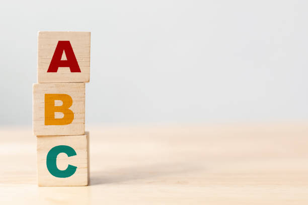 abc letters alphabet on wooden cube blocks in pillar form on wood table - dictionary alphabet letter text imagens e fotografias de stock