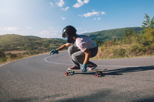 abenteuerliche longboarder-reiten an einem sonnigen tag - longboard skating stock-fotos und bilder