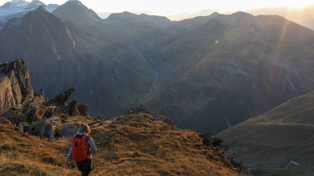 istock Female hiker walks along mountain ridge at sunrise 1192479488
