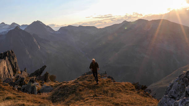 istock Hiker walks along mountain ridge at sunrise 1192479505