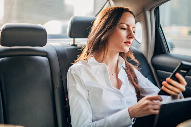 istock Business lady using mobile in backseat of a car 1192479678