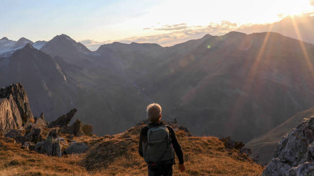 istock Hiker walks along mountain ridge at sunrise 1192479717