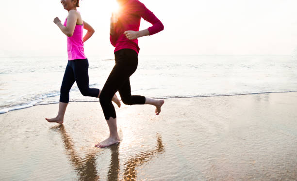 istock Two young women jogging along the beach 1192480153