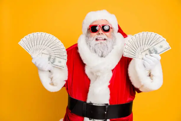 Credit bank x-mas lottery win. Funny funky white bearded santa claus hold double, money jackpot fan become north-pole millionaire wear red hat headwear isolated over yellow color background