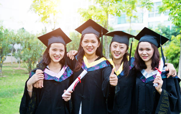 istock Four smiling graduates together on graduation day 1192481767
