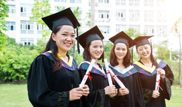 istock Four smiling graduates together on graduation day 1192482352