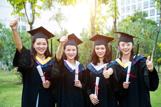 istock Four smiling graduates together on graduation day 1192482975