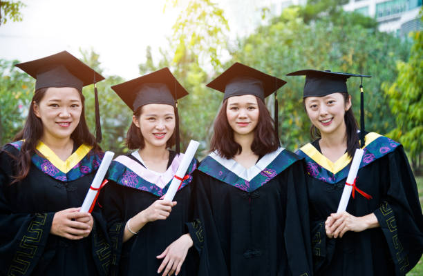 istock Four smiling graduates together on graduation day 1192483018
