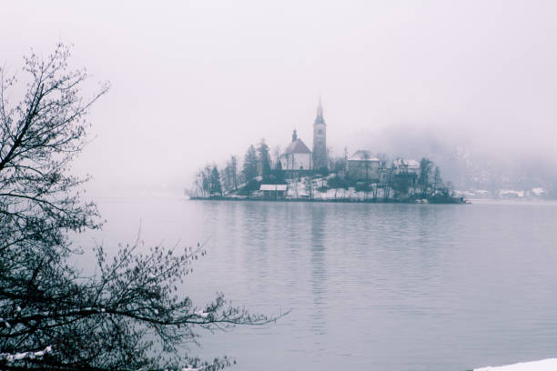 inverno al lago sanguinava. chiesa sull'isola - castle slovenia winter snow foto e immagini stock