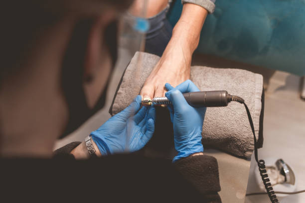 istock Pedicure master uses nail file drill for preparing nails for pedicure 1192487270