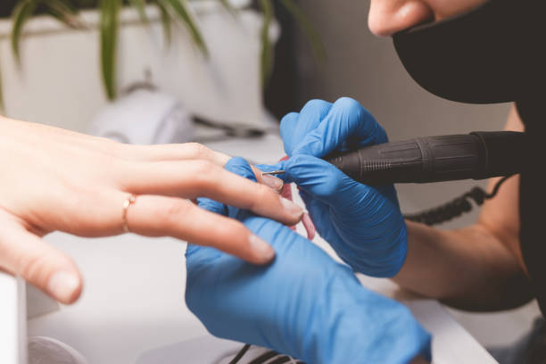 istock Manicurist cleans nails with a nail file drill before applying varnish 1192487871