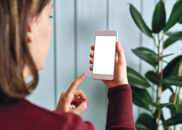 istock Woman holding and touching blank screen template smart phone. Smart phone screen is empty with clipping path. 1192491623