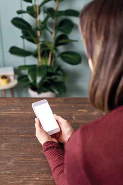 istock Woman holding and touching blank screen template smart phone. Smart phone screen is empty with clipping path. 1192491643