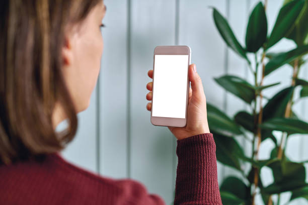 istock Woman holding and touching blank screen template smart phone. Smart phone screen is empty with clipping path. 1192491670