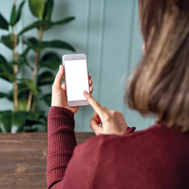 istock Woman holding and touching blank screen template smart phone. Smart phone screen is empty with clipping path. 1192491684