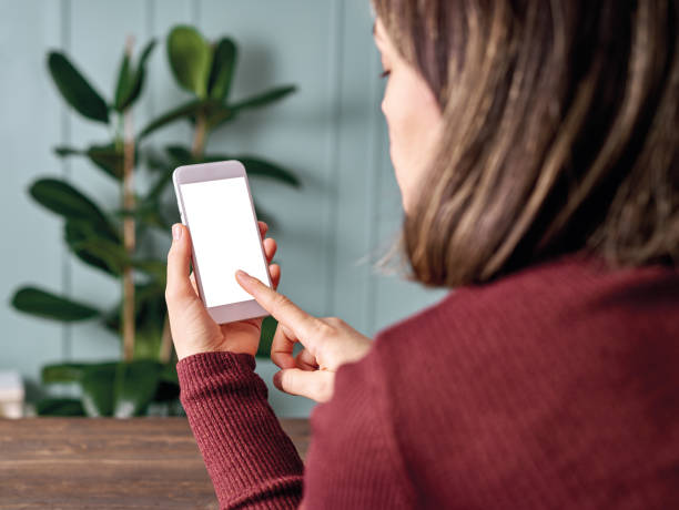 istock Woman holding and touching blank screen template smart phone. Smart phone screen is empty with clipping path. 1192491694